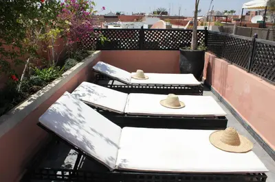 three picnic tables on a balcony with hats on them at Riad Le Bel Oranger in Marrakech