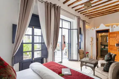 a living room with a bed and a large window at Riad Twilight in Marrakech