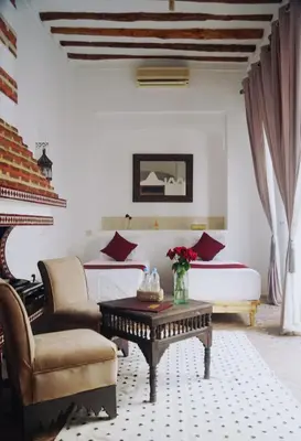 a bedroom with a bed and a couch and a table at Riad Twilight in Marrakech