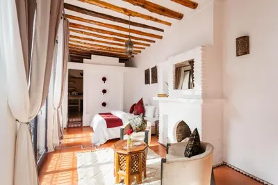 a living room with a bed and a fireplace at Riad Twilight in Marrakech