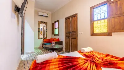 a bedroom with a bed and a living room at Riad Ghali Hotel & SPA in Marrakech