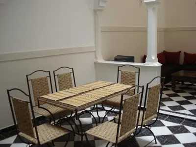 a table and chairs in a room with a checkered floor at Riad Hicham in Marrakech in Marrakech