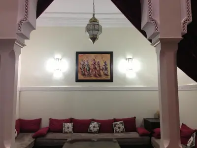 a living room with a couch and a painting on the wall at Riad Hicham in Marrakech in Marrakech