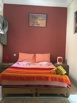 a bed in a bedroom with a red wall at Riad Hicham in Marrakech in Marrakech