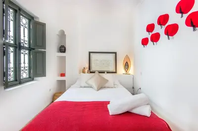 a bedroom with a bed with a red blanket at Riad Myla - 2mn de Jemaa El Fna in Marrakech
