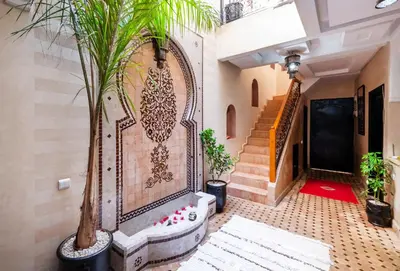 a hallway with stairs and a wall with a mural at Riad Elite in Marrakech