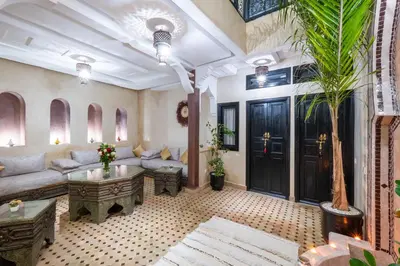 a living room with a couch and a palm tree at Riad Elite in Marrakech