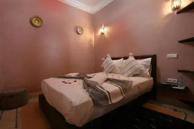 a bedroom with a bed with white sheets and pillows at Riad Elite in Marrakech