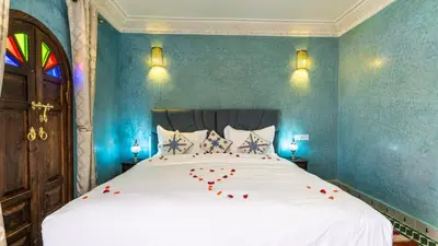 a bedroom with a bed with red roses on it at Riad Bab Tilila in Marrakech