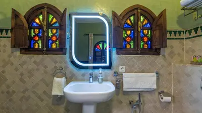 a bathroom with a sink and stained glass windows at Riad Bab Tilila in Marrakech