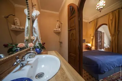 a bathroom with a sink and a bed in a room at Riad Bab Tilila in Marrakech