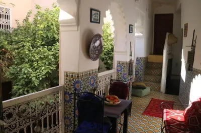 a balcony with a table and chairs and plants at RIAD Redous in Marrakech