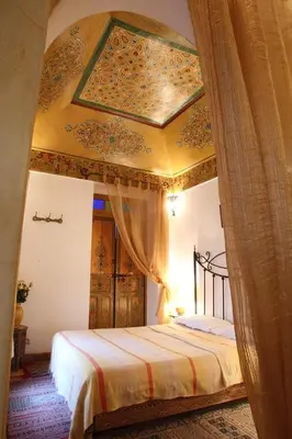 a bedroom with a canopy bed with a ceiling at RIAD Redous in Marrakech