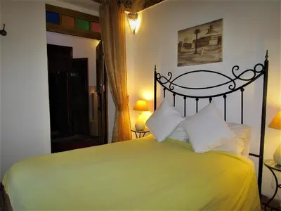 a bedroom with a green bed with white pillows at RIAD Redous in Marrakech