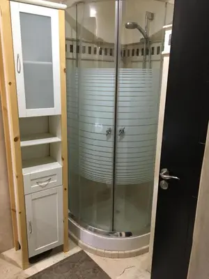 a shower with a glass door in a bathroom at pascal Apartment in Marrakech