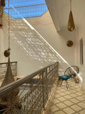 a staircase in a house with a blue ceiling at Riad Papadou in Marrakech