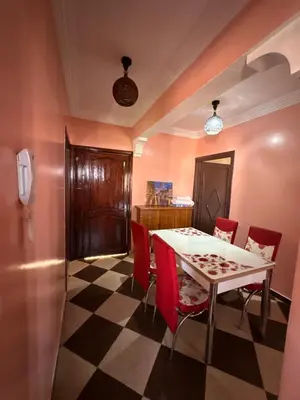 a dining room with a table and red chairs at Marrakech Family appartements in Marrakech