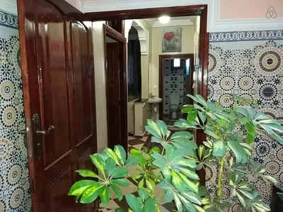 a hallway with a wooden door and plants at Marrakech Family appartements in Marrakech