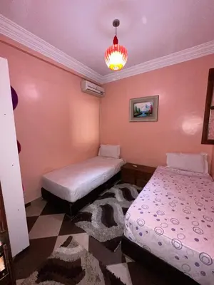 a bedroom with two beds and a chandelier at Marrakech Family appartements in Marrakech