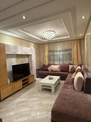a living room with a couch and a television at Appartement haut standing in Marrakech