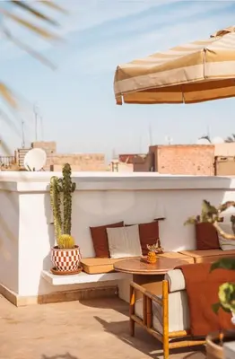 a patio with a table and an umbrella at Riad L'Atelier in Marrakech