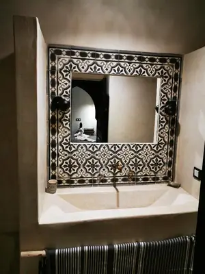 a bathroom with a mirror and a bath tub at Riad Bab aylen - Piscine Roof Top chauffée in Marrakech