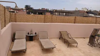 a patio with chairs and a table on a balcony at Riad Taziri in Marrakech