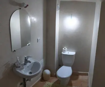 a bathroom with a white toilet and a sink at Riad Taziri in Marrakech