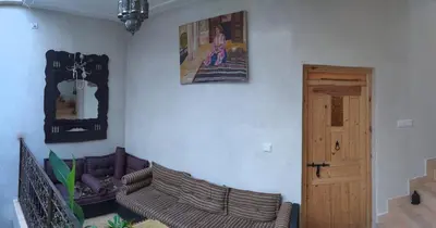a living room with a couch and a picture on the wall at Riad Taziri in Marrakech