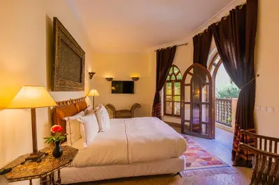a bedroom with a bed with a table and a window at Riad Il Parco dei Principi in Marrakech