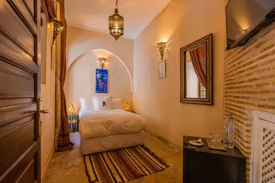 a hotel room with a bed and a mirror at Riad Il Parco dei Principi in Marrakech