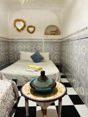 a room with a bed and a table with a hat on it at Hannah House Marrakech in Marrakech