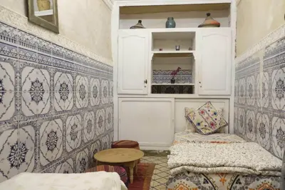 a room with a bed and a table and a wall at Hannah House Marrakech in Marrakech