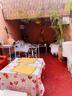 a room with two beds and a table with a blanket at Hannah House Marrakech in Marrakech