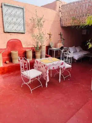 a room with a table and chairs on a red floor at Hannah House Marrakech in Marrakech