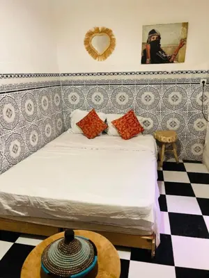 a bedroom with a bed and a checkerboard floor at Hannah House Marrakech in Marrakech