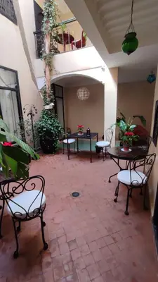 a patio with chairs and tables in a building at RIAD PÉNÉLOPE Marrakech in Marrakech