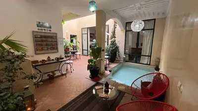 a living room with a swimming pool and some plants at RIAD PÉNÉLOPE Marrakech in Marrakech
