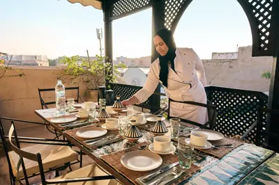 a woman standing in front of a table at Riad Nomada Marrakech in Marrakech
