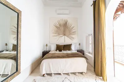 a bedroom with a bed and a mirror at Riad Nomada Marrakech in Marrakech