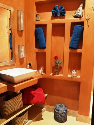 a bathroom with a sink and a mirror and blue towels at Riad Bilkis Votre Maison Marrakech in Marrakech