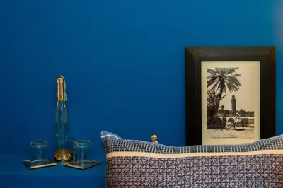 a blue wall with a picture of a palm tree at Riad Bilkis Votre Maison Marrakech in Marrakech