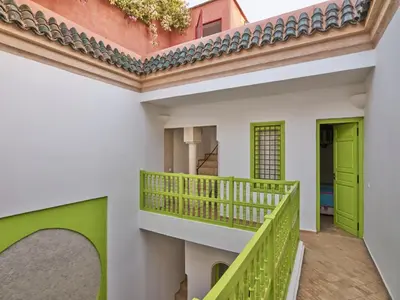 a balcony of a house with green doors at Riad Volubilis in Marrakech
