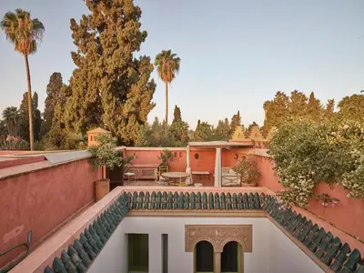 a view of the courtyard of a house with palm trees at Riad Volubilis in Marrakech