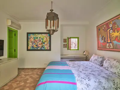 a bedroom with a bed and a painting on the wall at Riad Volubilis in Marrakech
