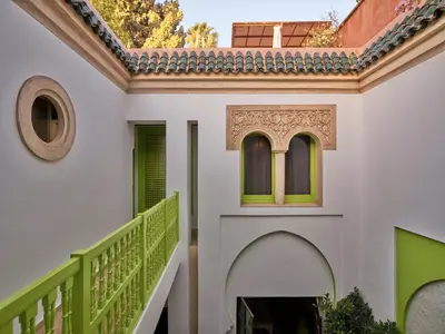 a house with a staircase and a green railing at Riad Volubilis in Marrakech