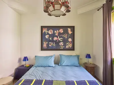 a bedroom with a bed with a painting on the wall at Riad Volubilis in Marrakech