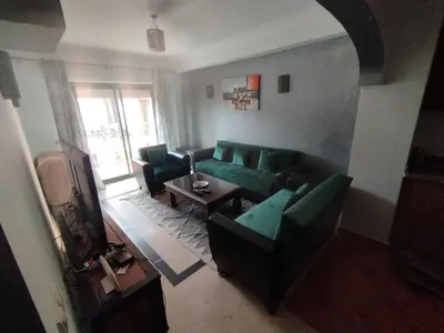 a living room with a green couch and a table at appartment achwaq in Marrakech