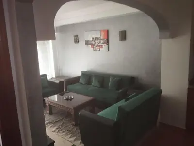 a living room with a green couch and a table at appartment achwaq in Marrakech