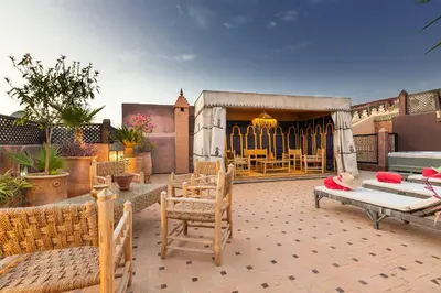 a patio with chairs and tables and a building at Riad AZARO in Marrakech